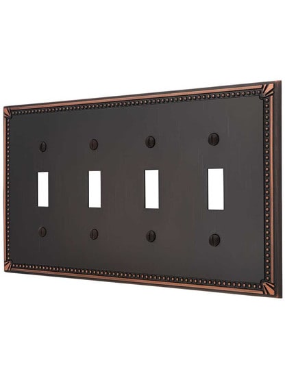 Imperial Bead Quad Gang Toggle Switch Plate in Aged Bronze.